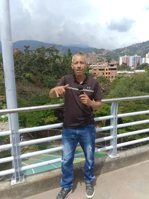 Jaime Ramirez en un puente con las montañas de Medellín al fondo