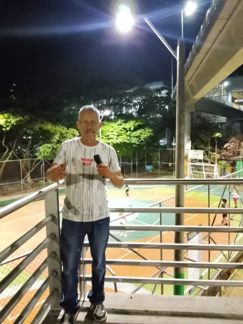 Jaime Ramirez en una pasarela sobre una cancha iluminada de noche